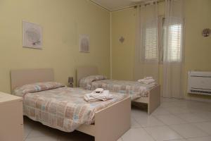 Dos camas en una habitación de hospital con toallas. en Appartamento in Villa, en Torrenova