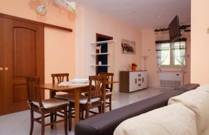 sala de estar con sofá, mesa y sillas en Appartamento in Villa, en Torrenova