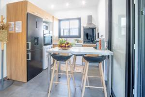 a kitchen with a white counter and a refrigerator at Ô Ruisseau Lodge lodge Cocotier in Saint-Louis