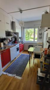 a kitchen with red cabinets and a table at Peaceful and beautiful apartment in Hämeenlinna in Hämeenlinna