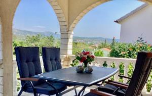 a table with a vase of flowers on a porch at Apartmani Mate in Rogoznica