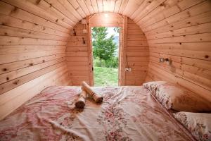 a large bed in a wooden room with a window at Cozy barrel in Nikšić