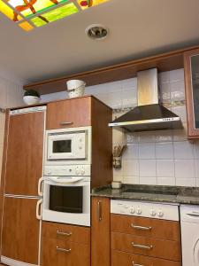 a kitchen with a white stove and a microwave at EL 22 DE CASTROVIEJO in Logroño