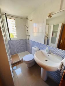 La salle de bains est pourvue de toilettes blanches et d'un lavabo. dans l'établissement Maravilloso Complejo Residencial, à Benidorm