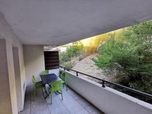 een balkon met een tafel en stoelen erop bij Magnifique appartement pour 8 personnes à Montpellier - WIFI/PARKING in Montpellier