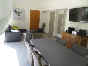 a living room with a table and chairs and a flat screen tv at Villa neuve piscine chauffée - St Vallier de Thiey in Saint-Vallier-de-Thiey