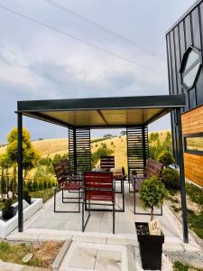 a pergola with chairs and a table on a patio at Wild nest Deer Lux in Zlatibor