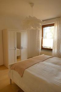 a bedroom with a white bed and a window at Ferienwohnung Wengerner Mühle in Wetter