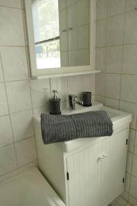 a bathroom sink with a grey towel on it at Ferienwohnung Wengerner Mühle in Wetter