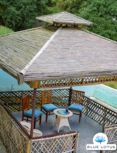 um gazebo com 4 cadeiras, uma mesa e uma mesa em Blue Lotus by M - Resort and Camps em Mukteswar