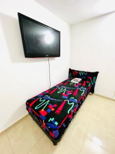 a bedroom with a bed with a tv on the wall at ТИХАЯ КВАРТИРА ДЛЯ ОТДЫХА! in Haifa