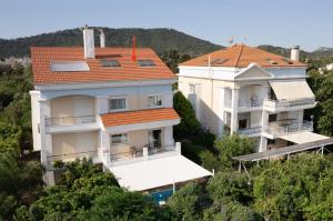 two large white buildings with a red roof at A&B Ialysos villas and apartments in Ialysos