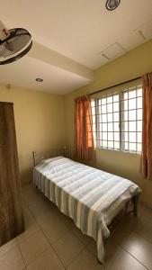 een slaapkamer met een bed in een kamer met een raam bij Eehome in Ipoh