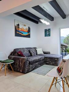 uma sala de estar com um sofá de couro preto e cadeiras em Hill House Valiug Crivaia em Valiug