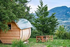 een houten hut met een tafel en een bank bij Cozy Barrel in the Hills in Nikšić
