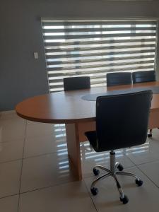 einen Tisch in einem Büro mit Stühlen um ihn herum in der Unterkunft Fumas guesthouse in Duvhapark