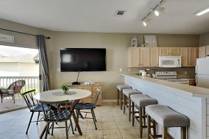 een keuken met een bar met stoelen en een tafel bij Sandpiper Cove 9224 in Destin