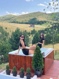 two women in bathing suits sitting on a hot tub at Zlatibor Wild nest Rabbit in Zlatibor