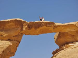 dois cães sentados em cima de uma formação rochosa em Russell desert camp em Disah