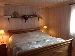 um quarto com uma cama num quarto com paredes de madeira em Bjørnehuset em Sønstebø