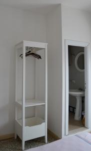 Armario blanco con espejo en el baño en Hotel Aurora Nord, en Rímini