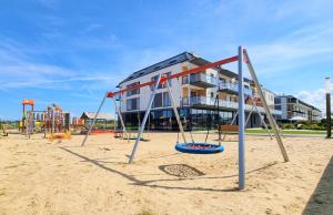 an empty playground in front of a building at Apartament z basenem Sarbinowo in Sarbinowo