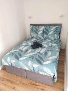 a bed with a blue comforter in a bedroom at Apartament z basenem Sarbinowo in Sarbinowo