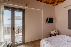 a bedroom with a bed and a balcony with an umbrella at Dream Villas Stoupa in Stoupa