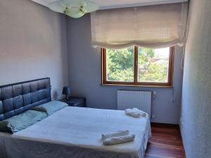 um quarto com uma cama grande e uma janela em Apartamento Malzapatu - 4 dormitorios - Llanes em Llanes