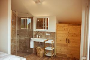 ein Bad mit einem Waschbecken und einer Dusche in der Unterkunft Pension Rudolfshöhe in St. Wolfgang