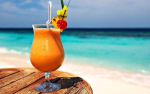 a drink sitting on top of a table on the beach at RIVER PARADISE in Goyave