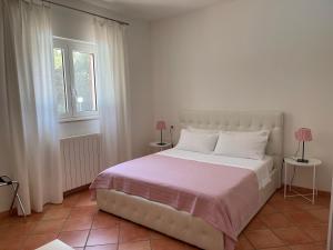 1 dormitorio con 1 cama blanca y 2 ventanas en Da Ksenia, en Ceglie Messapica