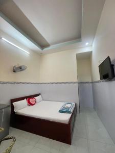 Cette petite chambre comprend un lit et une télévision. dans l'établissement My Linh Motel 976 Đường võ thị sáu long hải, à Long Hải