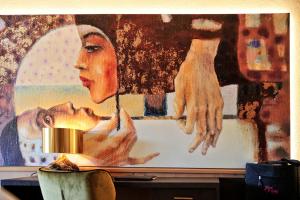 Eine Wand mit einem Gemälde einer Frau mit einer Säure in der Unterkunft Die Seefelderin - Boutiquehotel St. Georg in Seefeld in Tirol