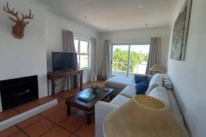 a living room with a couch and a tv at Golf Estate apartment close to the Beach in Cape Town