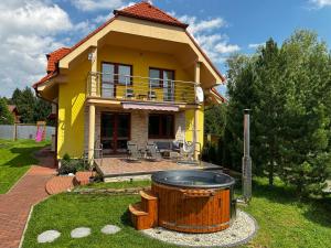 uma casa amarela com um grande barril à frente em Bikehouse em Veľká Lomnica