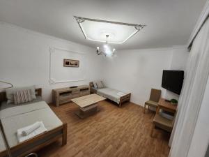 uma pequena sala de estar com uma cama e uma televisão em Cvet - Sobe em Bela Crkva
