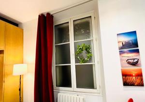 a window in a room with a red curtain at Dream Dwell Paris-Chic flat in the heart of Marais near Pompidou Centre in Paris