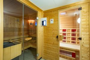eine Sauna mit Holzwänden und einer Glasduschkabine in der Unterkunft Batschari Palais Baden-Baden in Baden-Baden