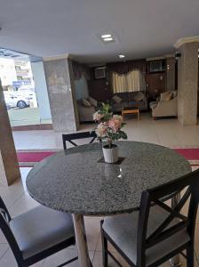 Jamjoom Hotel في جدة: طاولة عليها إناء من الزهور في غرفة المعيشة