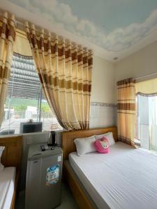 una camera con due letti e una finestra di My Linh Motel 976 Đường võ thị sáu long hải a Long Hai