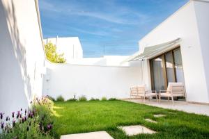 a white house with a green lawn in the yard at Ca’ Lezet in Guagnano