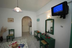 a living room with a television on a wall at Hotel Anixis Resort in Naxos Chora