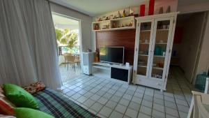 a living room with a tv and a desk with a computer at Ancorar Porto de Galinhas flat 7205 in Ipojuca