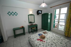 a bedroom with a bed and a table and a mirror at Hotel Anixis Resort in Naxos Chora