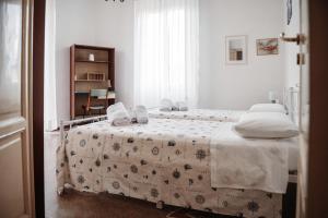 Dormitorio blanco con cama con manta en Casa elegante in mezzo al verde, en La Spezia
