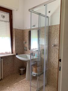 ein Bad mit einer Glasdusche und einem Waschbecken in der Unterkunft La casina del sole in Marina di Pietrasanta