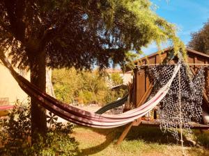 a hammock hanging from a tree next to a house at chez Guy in Marseille