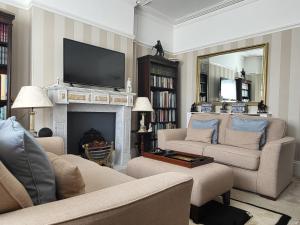 a living room with two couches and a fireplace at Sutherland House in Deal