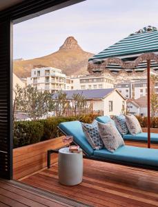 a couch on a deck with a view of a building at Pineapple House Boutique Hotel in Cape Town